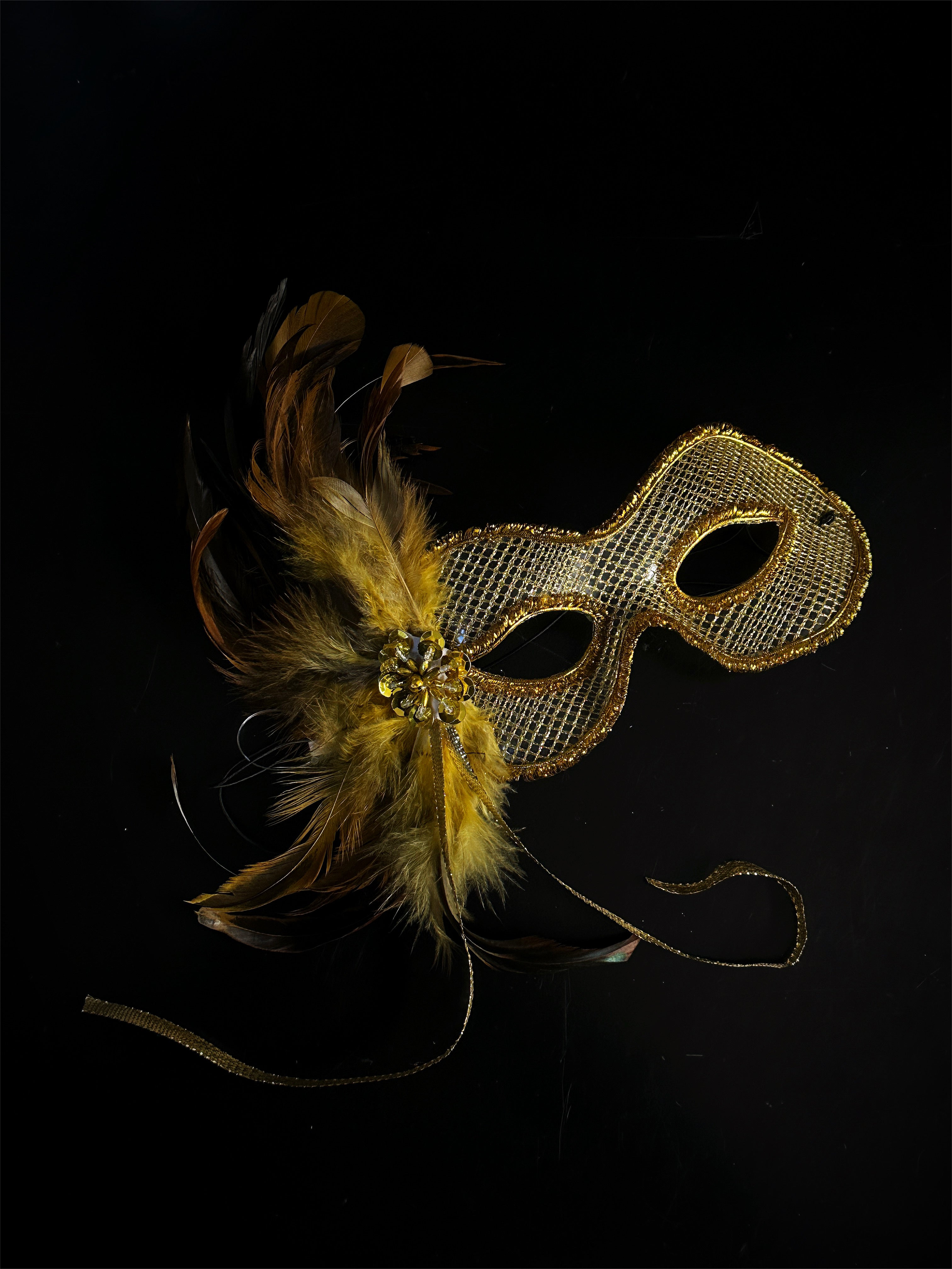 Womens gold masquerade mask with gold feathers.