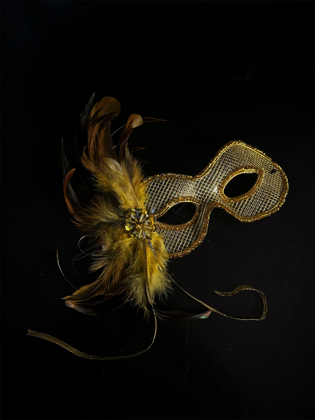 Womens gold masquerade mask with gold feathers.