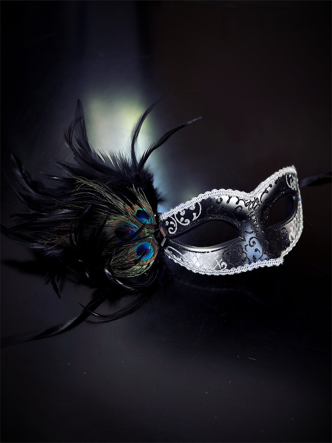 Womens black/silver masquerade mask with glitter and peacock feathers.