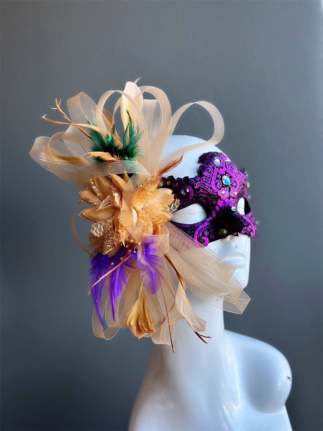 Womens masquerade mask in purple with gold, green, and purple feathers