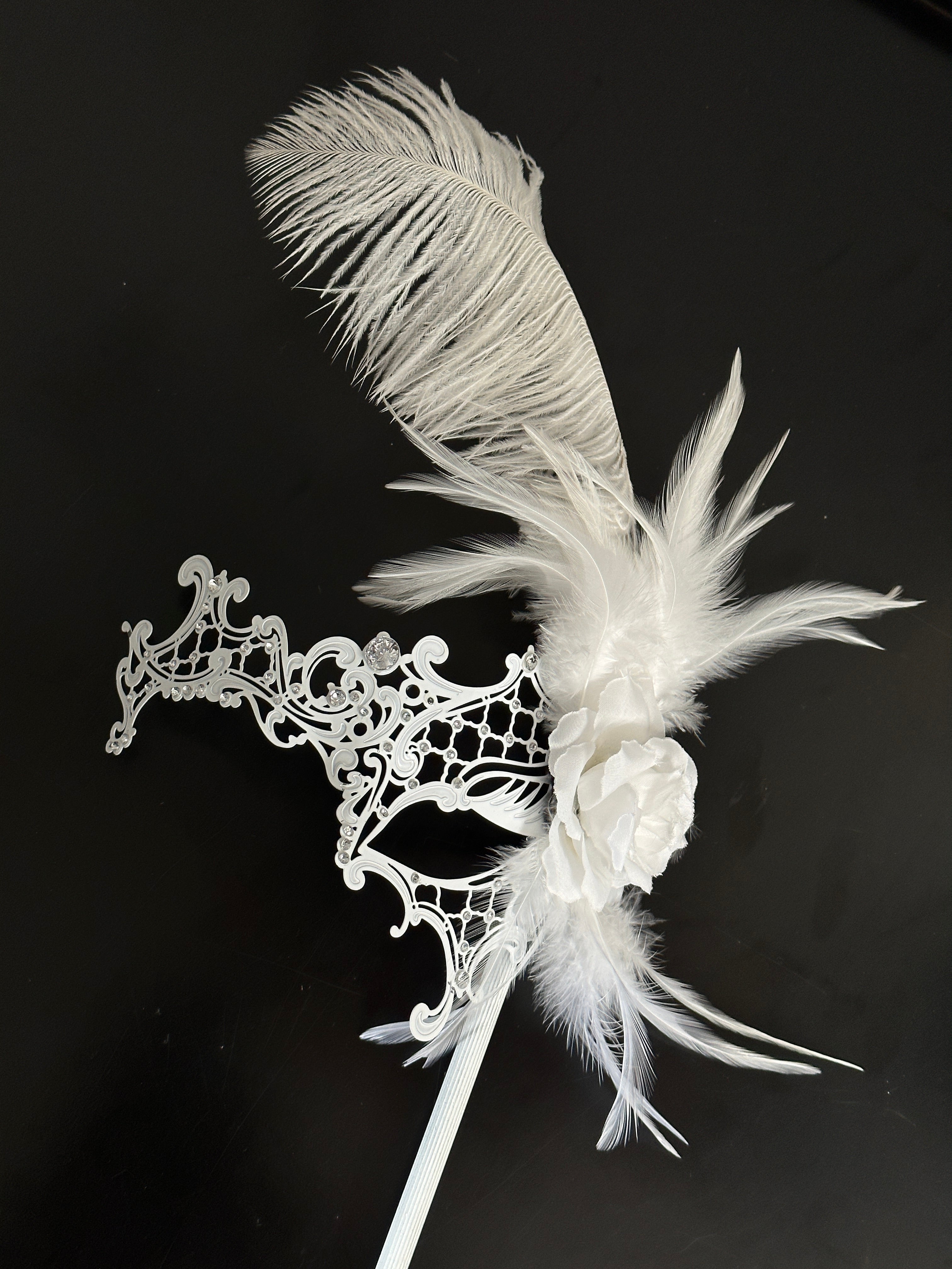 Handheld stick venetian mask with feathers in white for sale.