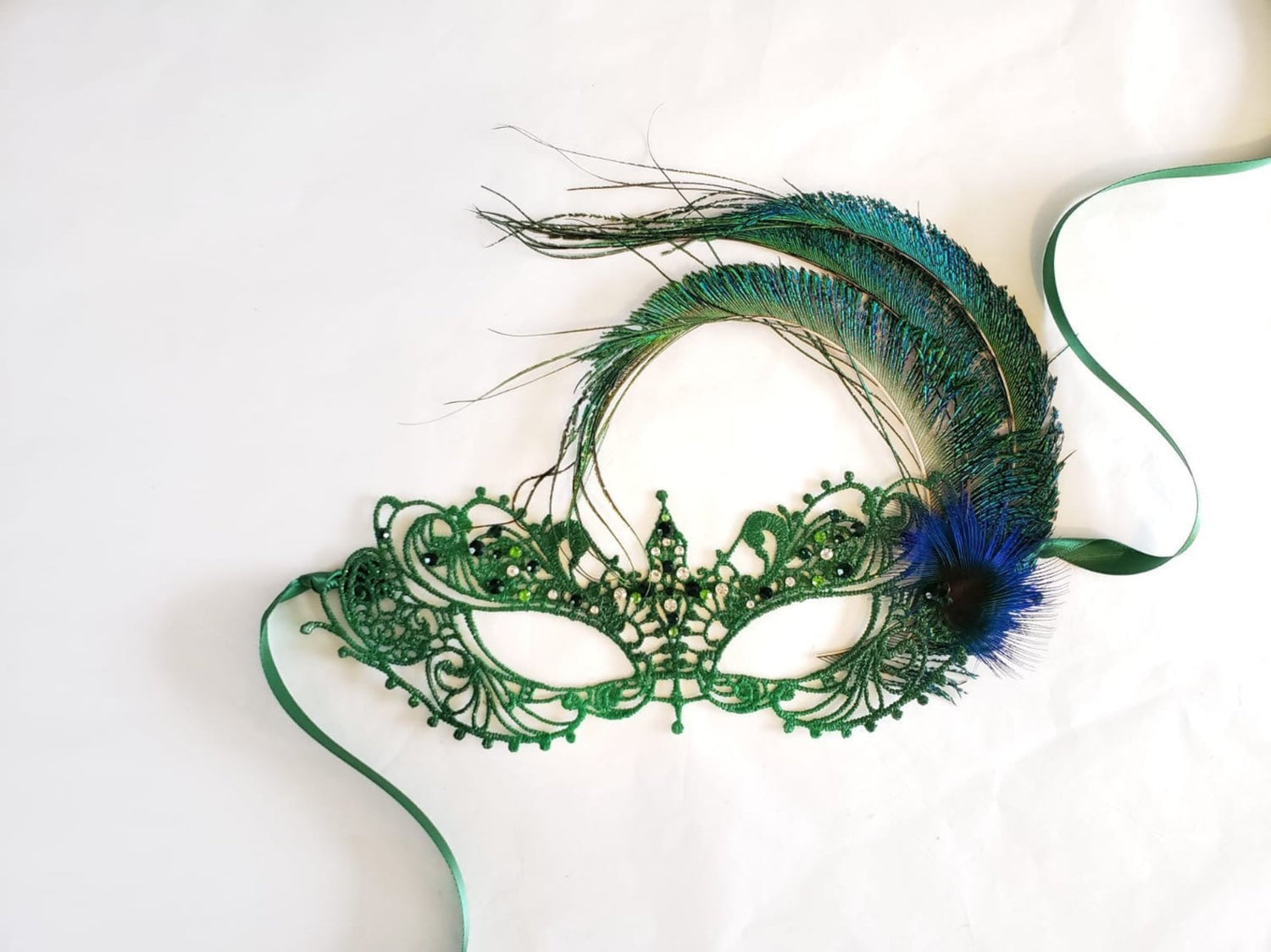 Womens masquerade mask with peacock feathers and green and clear rhinestones for sale.