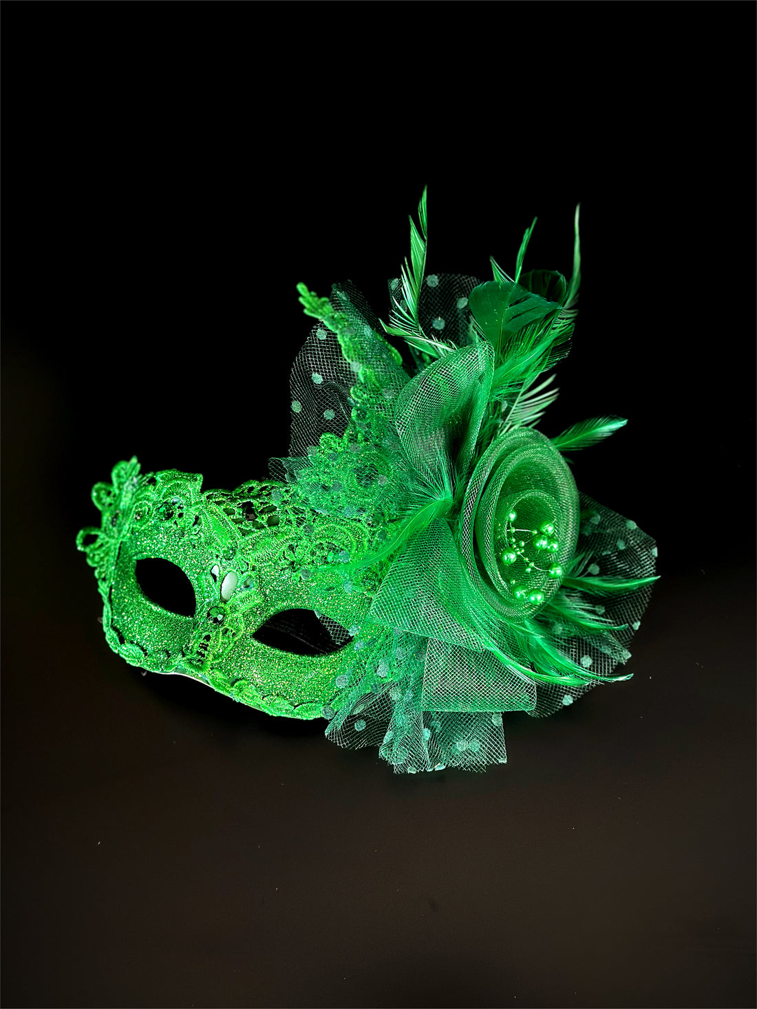 Green lace masquerade mask for women with glitter, feathers, and mesh rosette floral detail.