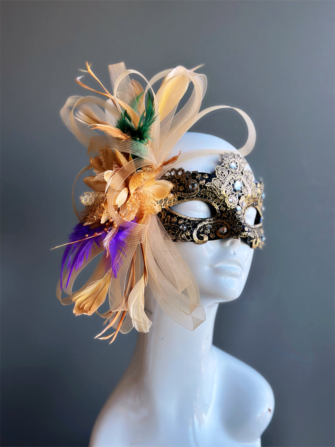 womens mardi gras masquerade mask in gold with green, gold, and purple feathers.