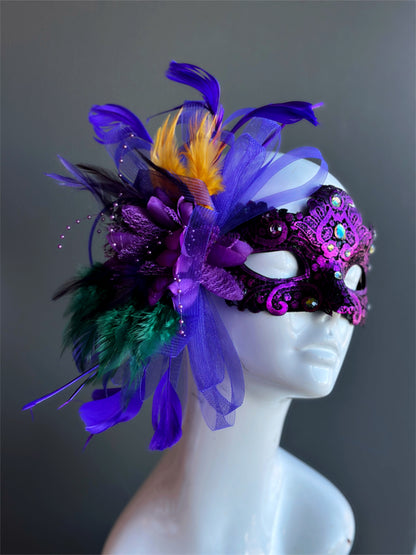 Womens masquerade mask in purple with gold green and purple feathers.