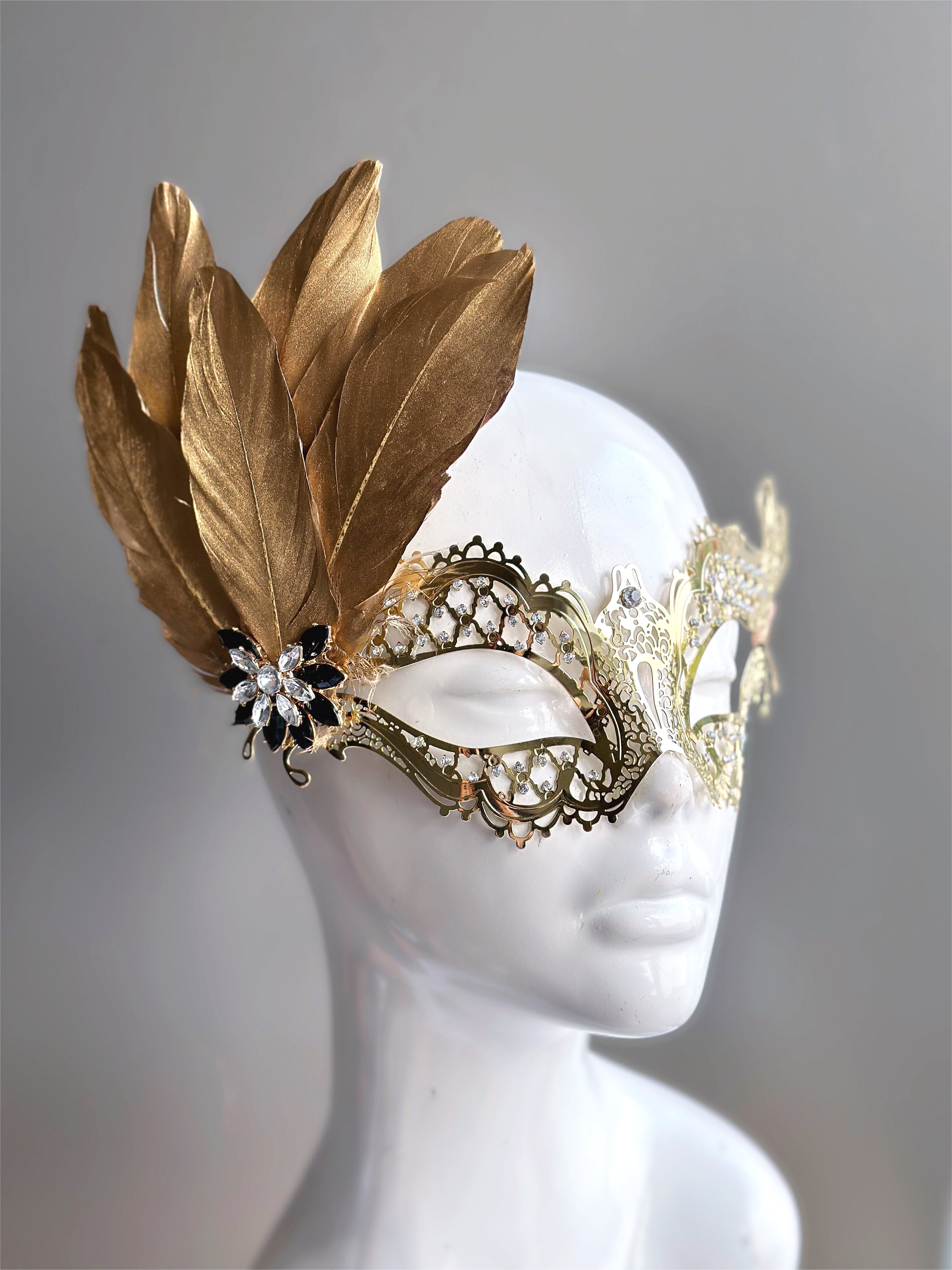 Womens masquerade laser cut metal mask in gold with gold feathers for sale.
