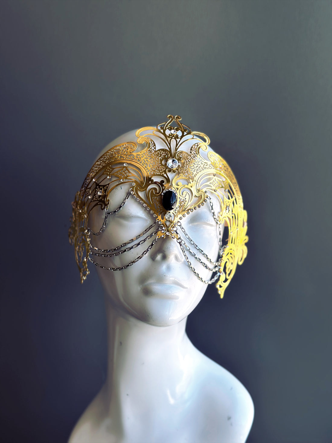 Womens masquerade mask in gold laser-cut metal with rhinestones and chains for sale.