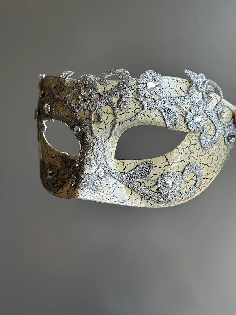 Side view of antique crackle Venetian masquerade mask with silver lace and rhinestone accents.