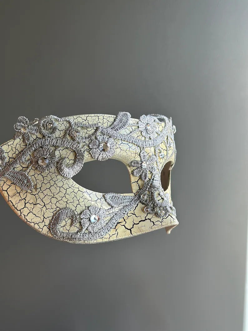 Side view of antique crackle Venetian masquerade mask with silver lace and rhinestone accents.