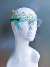 Aqua lace masquerade mask designed for eyeglass wearers displayed on a white mannequin head.