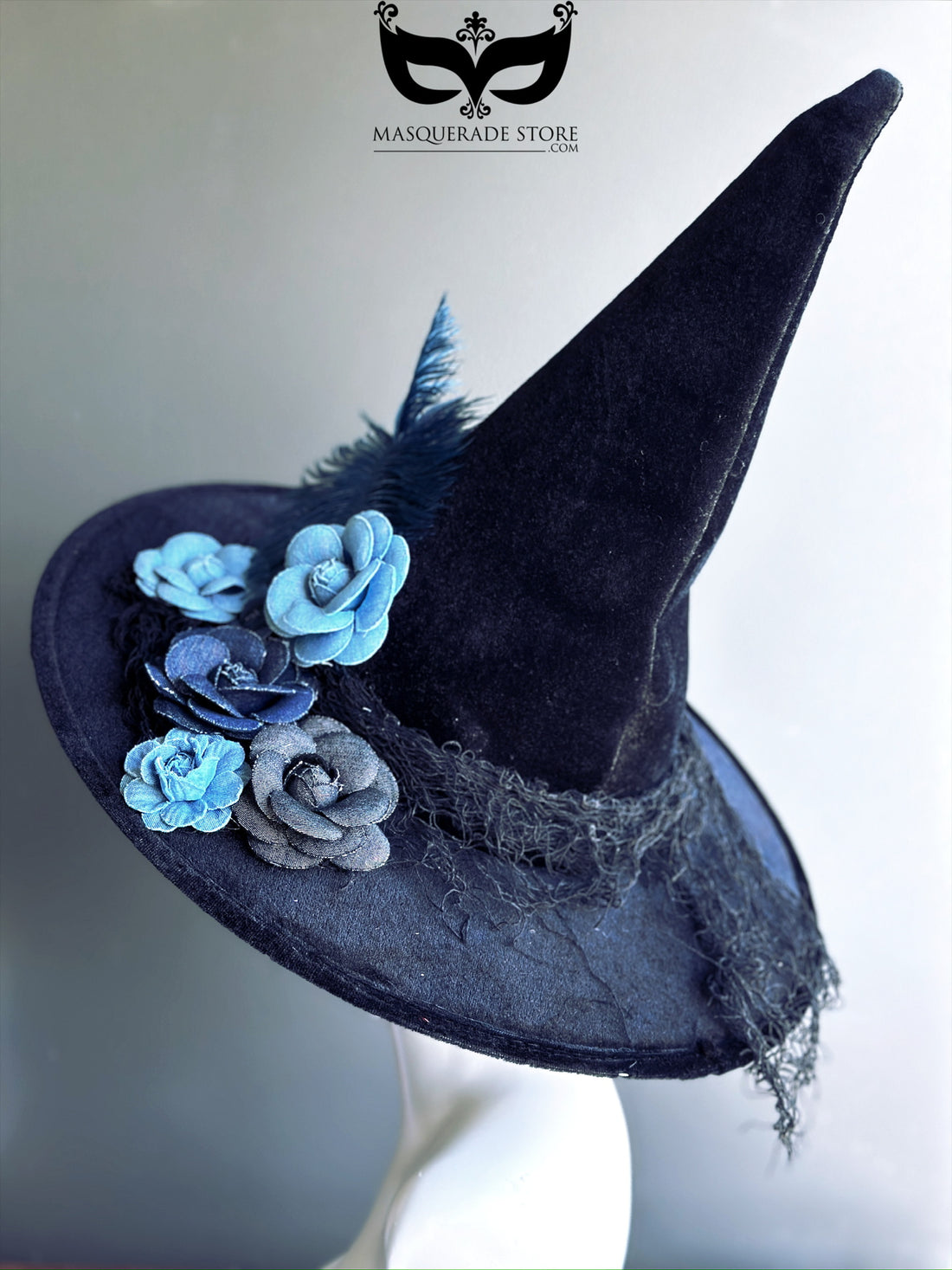 Black witch hat with blue denim flowers, feather accent, and rustic textured brim, perfect for Halloween or gothic fashion.
