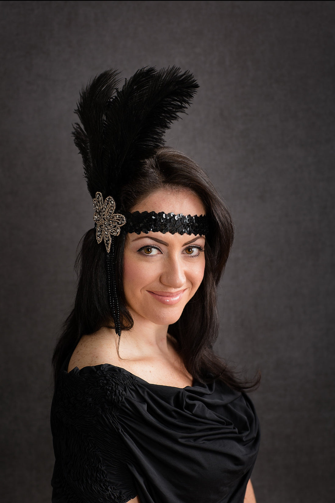 Black flapper headpiece with feather and beaded embellishment, perfect for 1920s Gatsby-themed parties or vintage events.