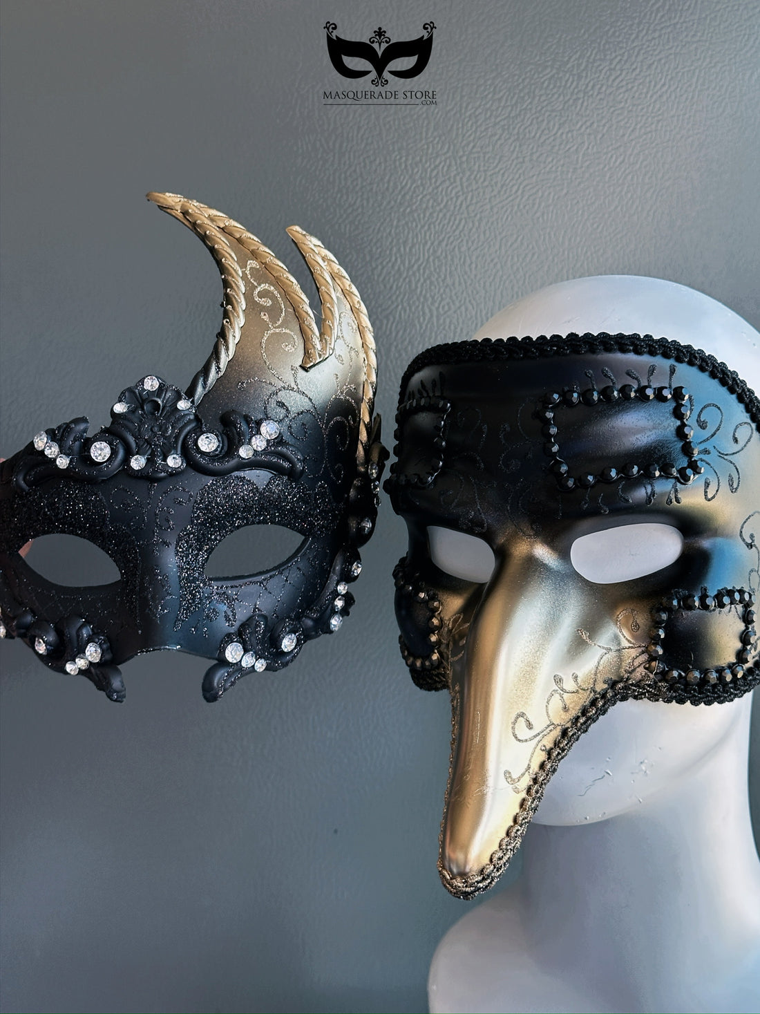 Couple’s masquerade mask set with black and gold designs, featuring jeweled horns for her and a Venetian long-nose mask for him.