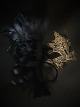 Elegant black and gold masquerade mask with feathers and filigree lace metal for women, perfect for Venetian balls and proms.
