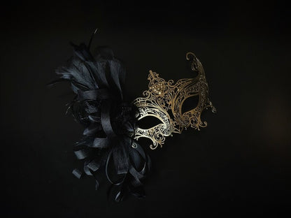 Elegant black and gold masquerade mask with feathers and filigree lace metal for women, perfect for Venetian balls and proms.