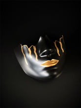 Black mask with gold accents, featuring minimalist art deco design

