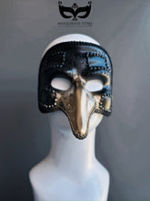 Black and gold plague doctor masquerade mask with long nose and ornate trim, inspired by Venetian Carnival traditions.