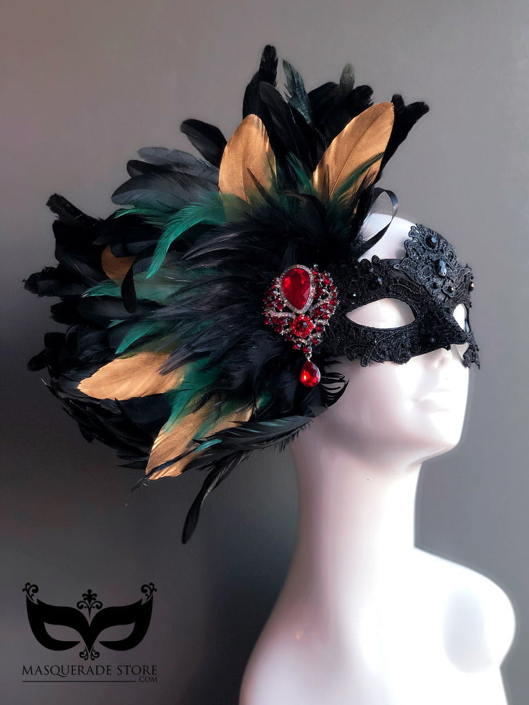 Black lace masquerade mask with green and gold feathers and red brooch for women.