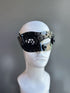 Men’s black steampunk mask with metallic gear accents and an industrial design, displayed on a mannequin.

