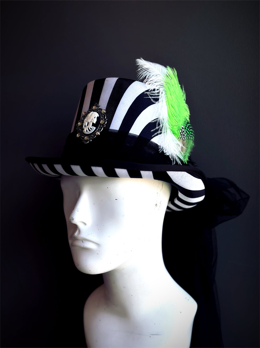 Black and white striped top hat with cameo and green feathers, Beetlejuice inspired