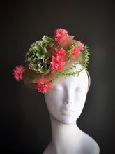 Fascinator hat with pink blossoms, green leaves, and tulle on a headband

