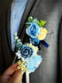 Blue and yellow prom boutonniere and corsage set with layered florals and greenery