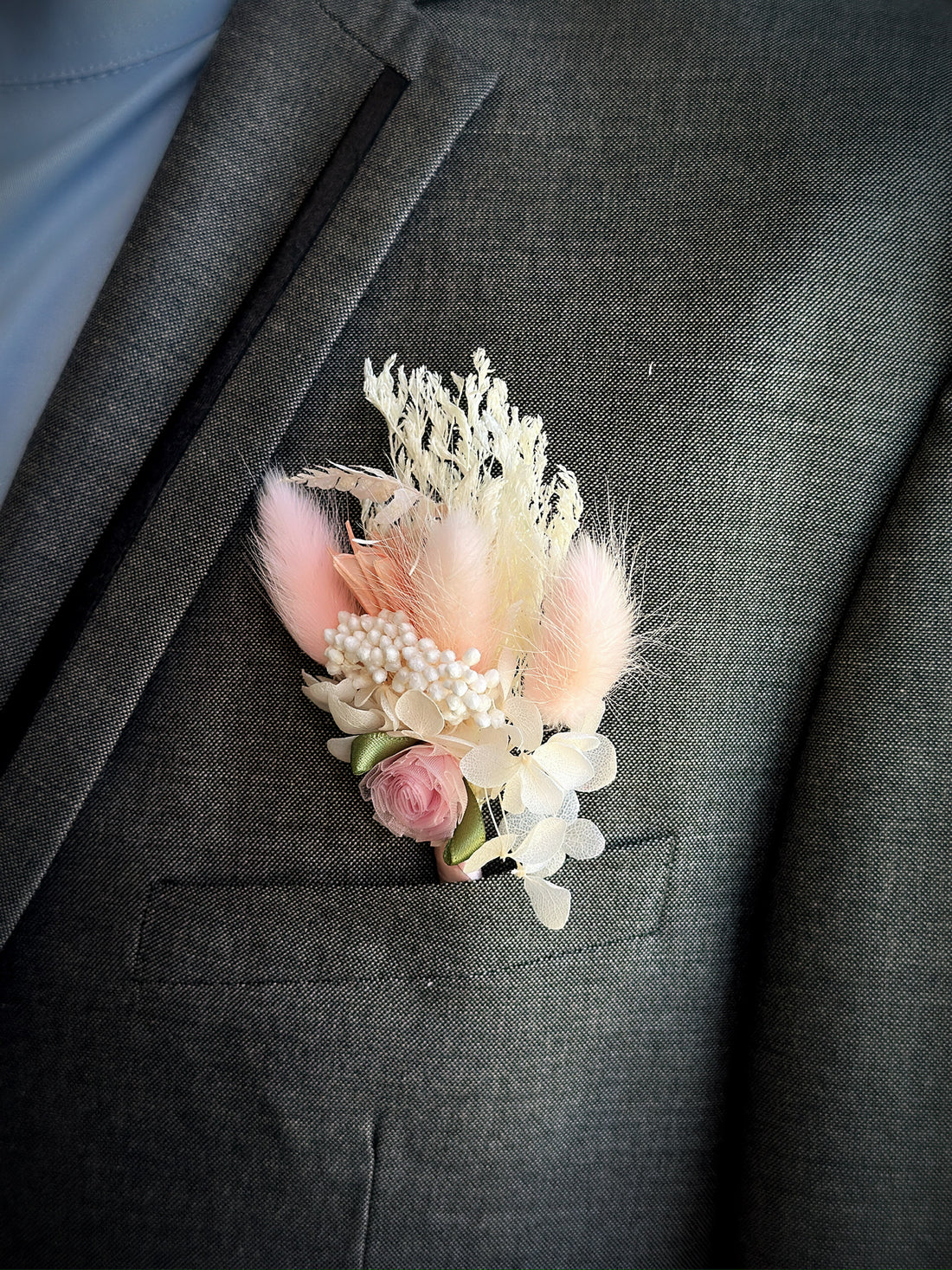 Blush pink prom boutonniere with feathers, pearls, and dried flowers