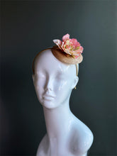 Blush pink floral piece on a beige sinamay hat base fixed on a matching headband
