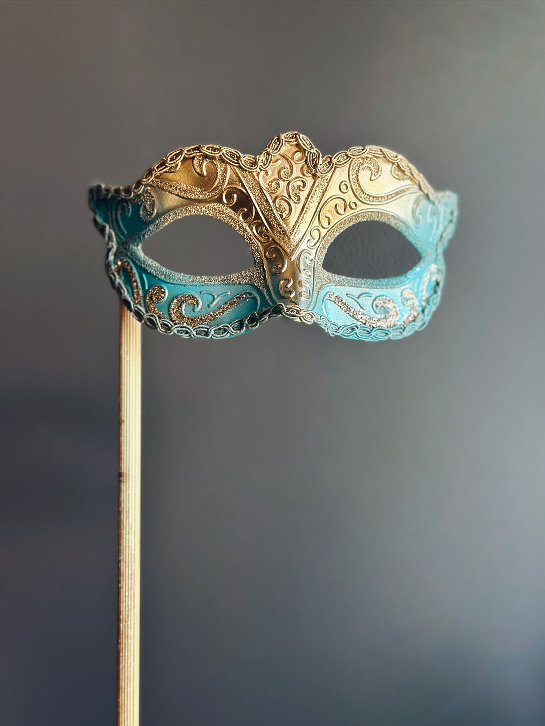 Gold and turquoise handheld masquerade mask with glitter and embossed swirl details