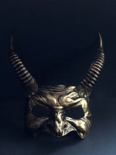 Bronze horned devil mask with intricate facial detailing and long, textured horns