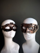 Bronze steampunk couples masquerade mask set with intricate gear detailing and industrial-inspired accents, displayed on mannequin heads.

