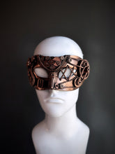 Bronze steampunk masquerade mask with detailed gears and mechanical accents displayed on a mannequin head.

