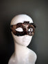 Bronze steampunk masquerade mask for women with intricate gear detailing and metallic accents, displayed on a mannequin head.

