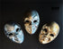 Bulk theatrical expression masks with metallic silver, antique gold, and dual-tone finishes featuring mysterious smiling sculpted faces.