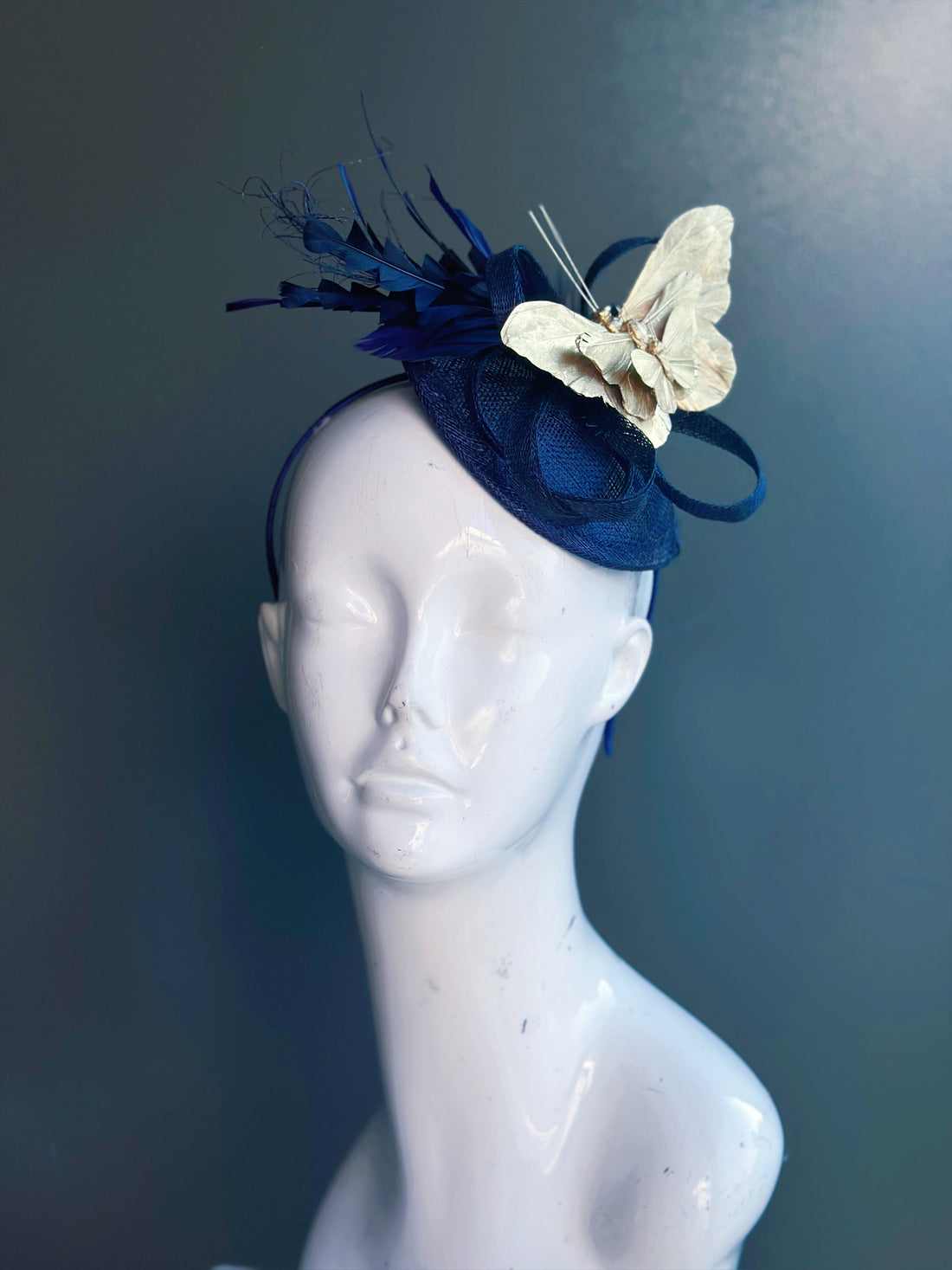Navy blue fascinator with gold butterflies and feathers, perfect for weddings and special events.
