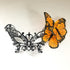Black filigree masquerade mask with orange monarch butterflies for women.