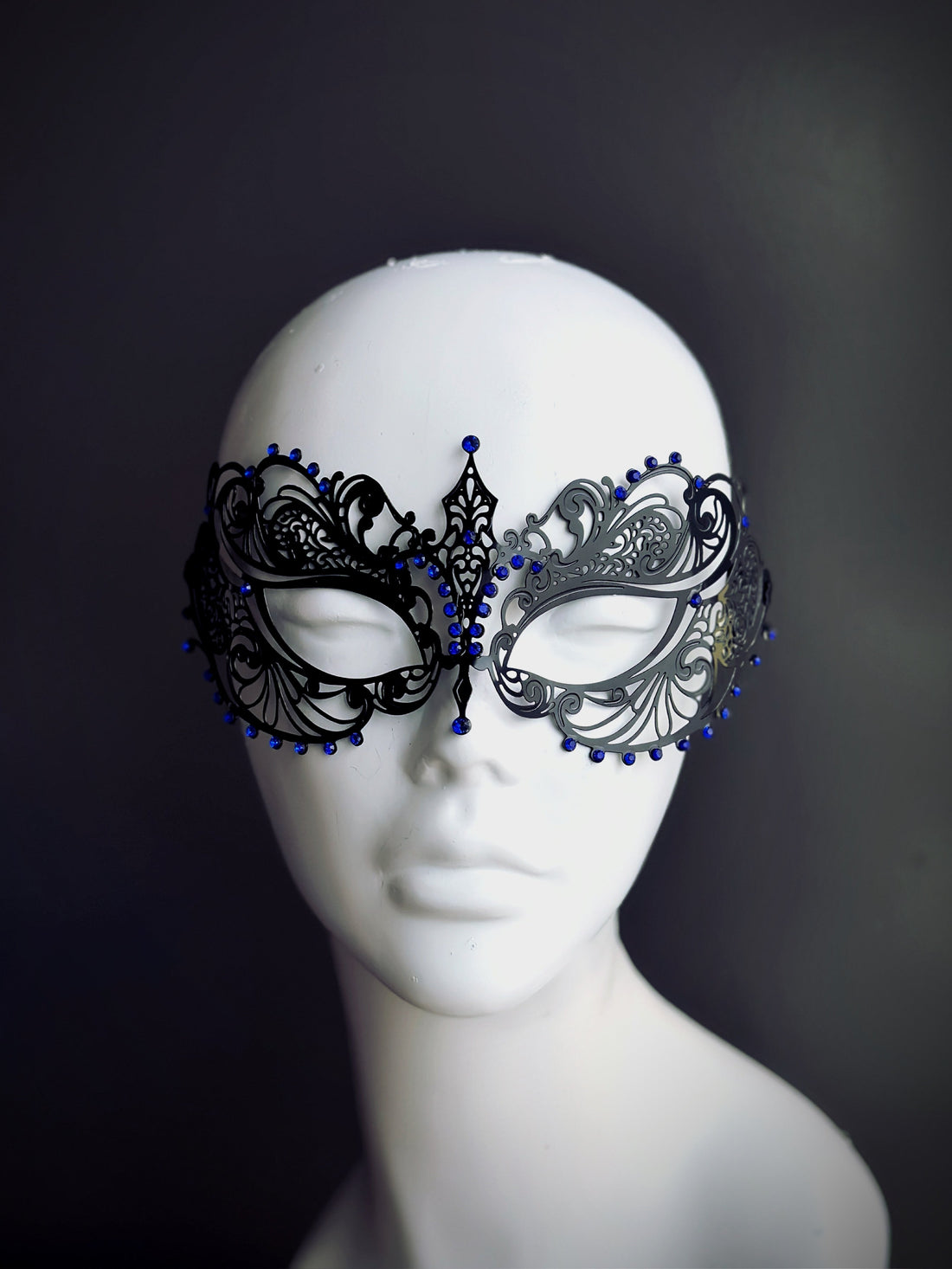 Black filigree metal masquerade mask with blue rhinestones