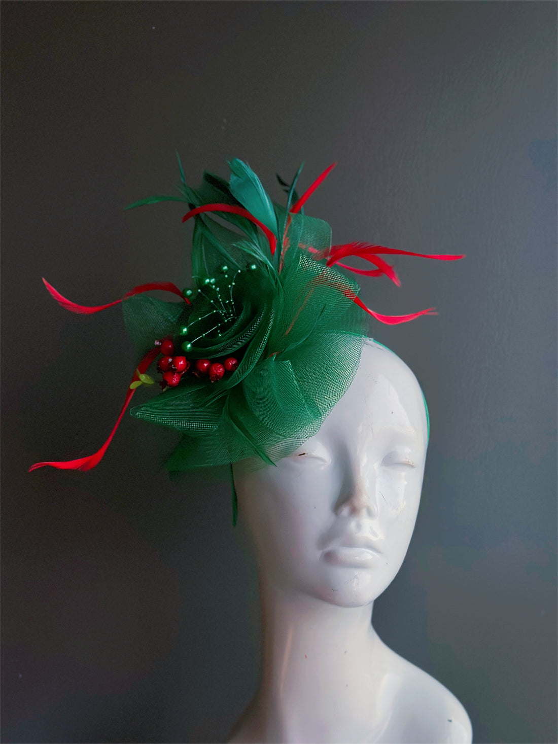 Christmas Celebration Fascinator in green and red with feathers, tulle, and berry accents