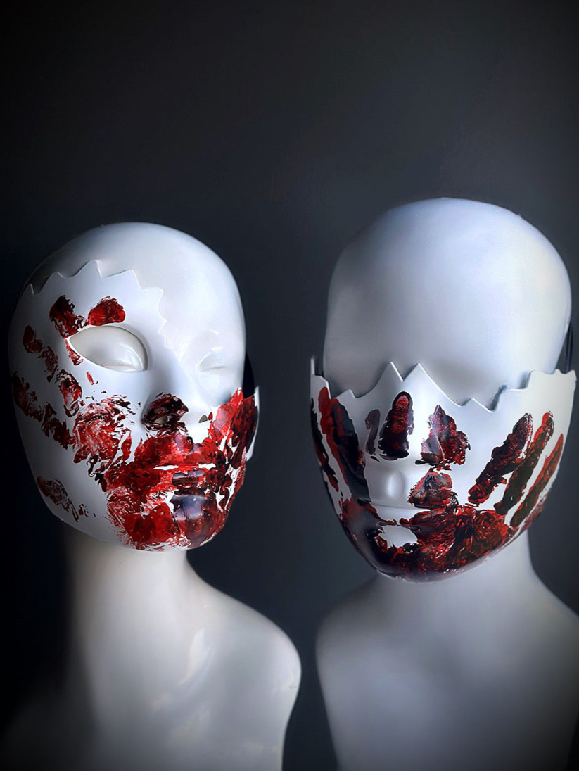 Oversized white masquerade mask set with bloody red handprints.