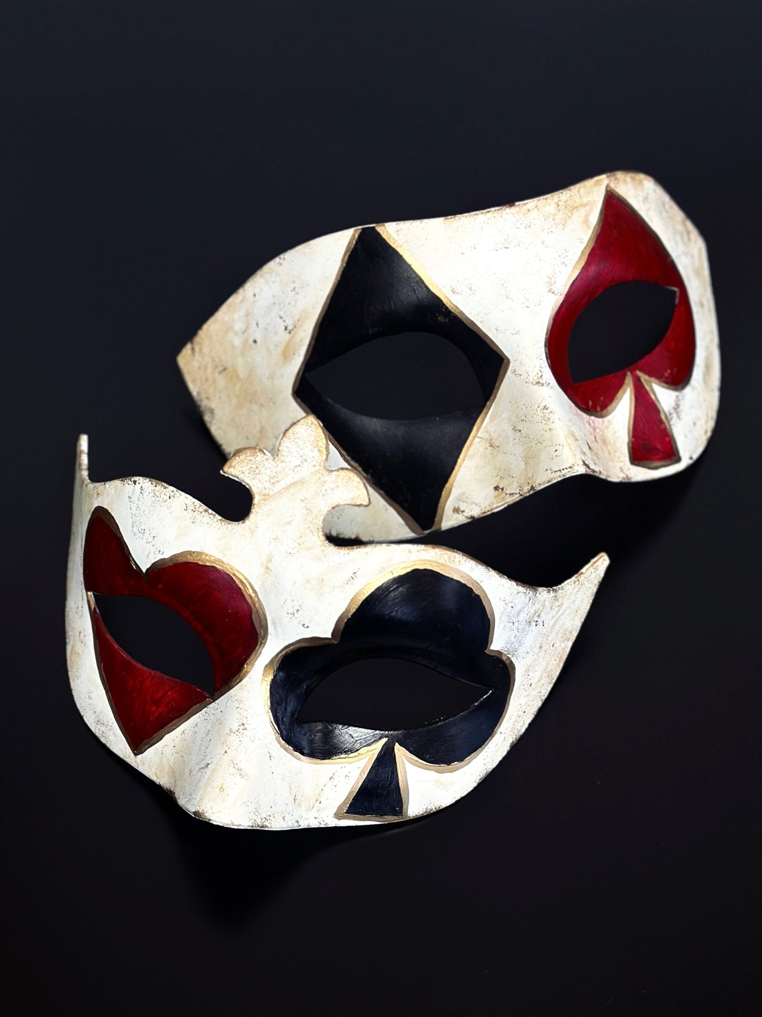 Couples masquerade mask set with black and red card suit symbols over the eyes and gold details.