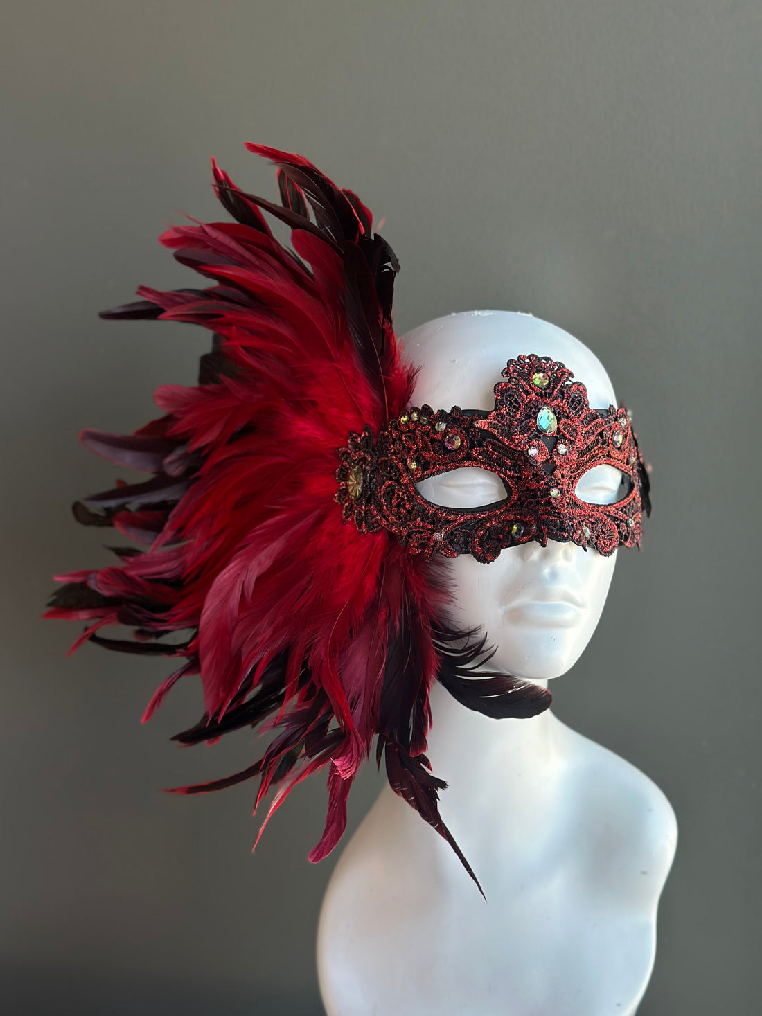 Ornate lace mask with red and black feathers, available plain or with a red or clear crystal brooch.