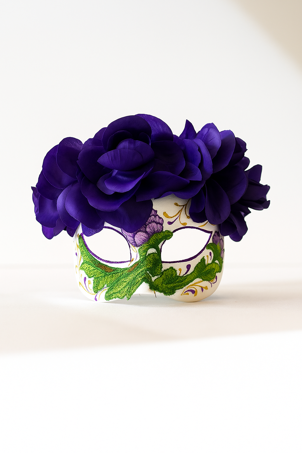 Sugar skull mask with purple floral crown and embroidered vine details for Dia de los Muertos.