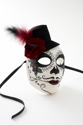 White sugar skull mask with black top hat, rose, and feather.