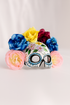 Colorful sugar skull mask with vibrant flower crown, Dia de los Muertos and Halloween skull costume mask with floral details.