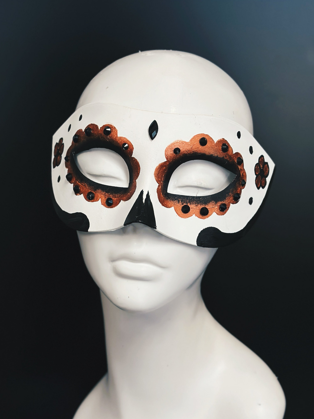 White masquerade mask base with copper and black sugar skull details and a black gem in the center.