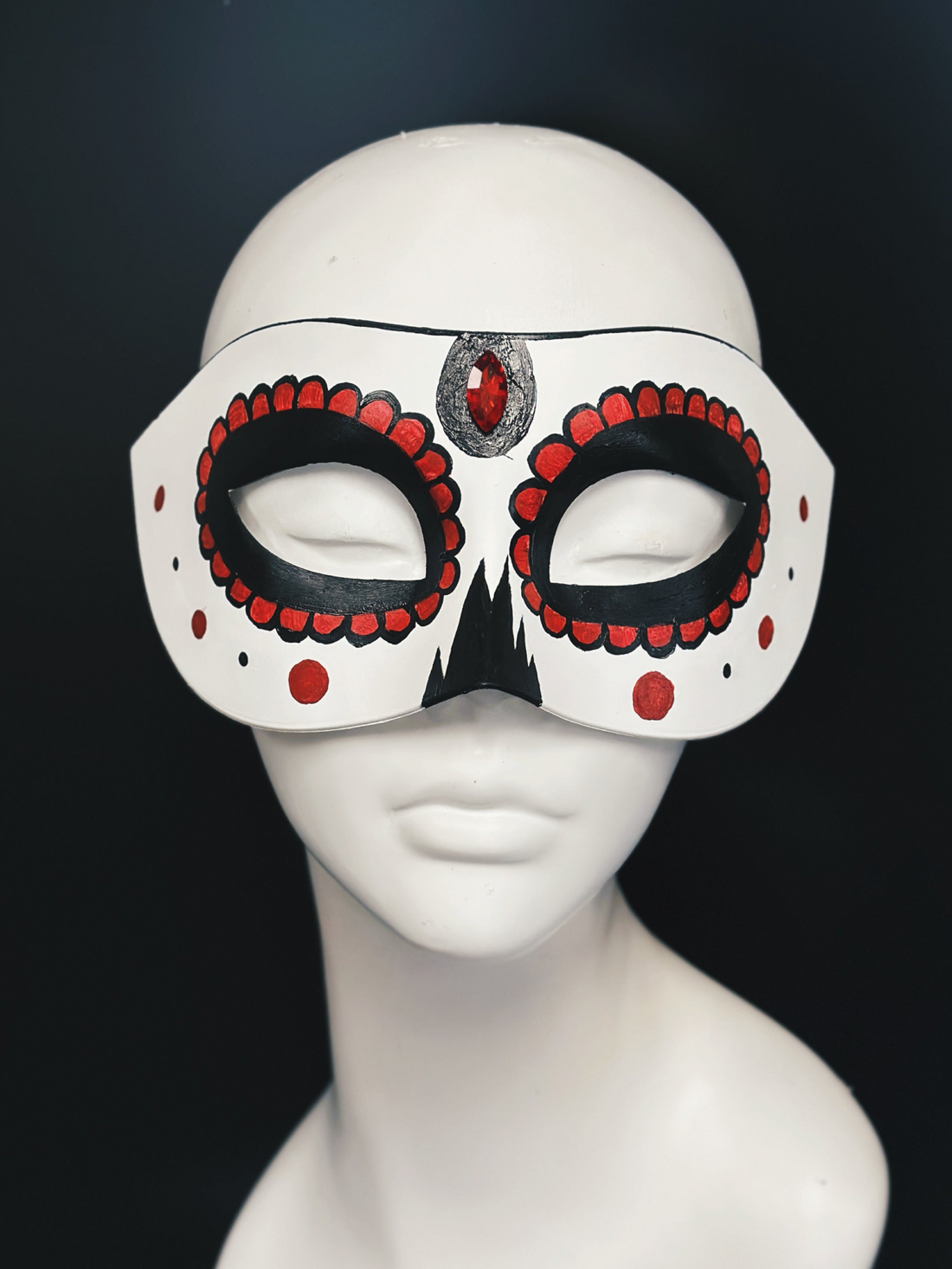 White masquerade mask base with red and black sugar skull details and a red gem in the center.