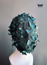 Emerald green butterfly face veil mask featuring dimensional butterfly appliqués attached to a sheer mesh hood, creating a couture-inspired avant garde fashion accessory for runway shows, cosplay, artistic performances, fantasy photoshoots, and fashion editorials.