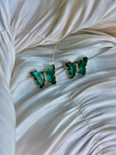 Emerald green butterfly earrings with faceted crystals and delicate accents.