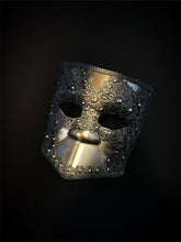 Venetian Bauta mask in gold and black with ornate lace overlay and crystal accents for an elegant, mysterious look.
