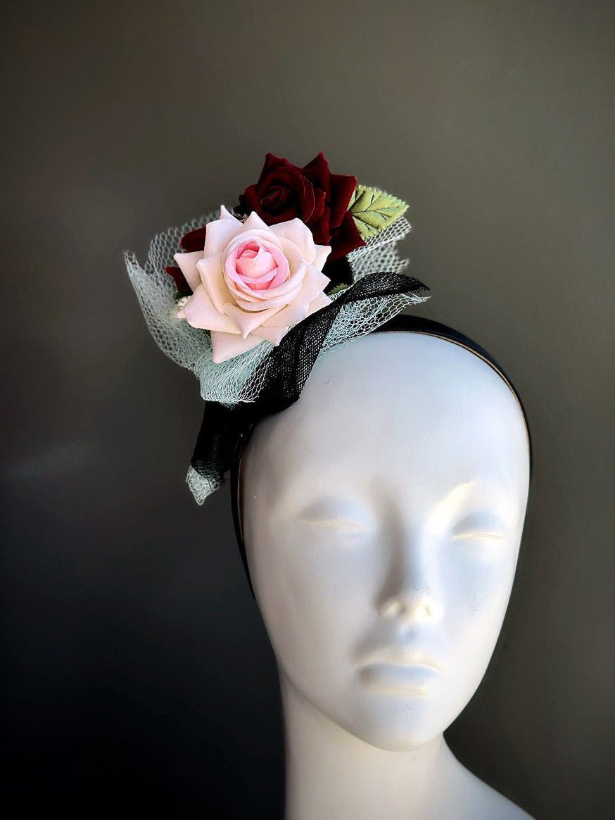 Fascinator with blue tulle and pink red roses.